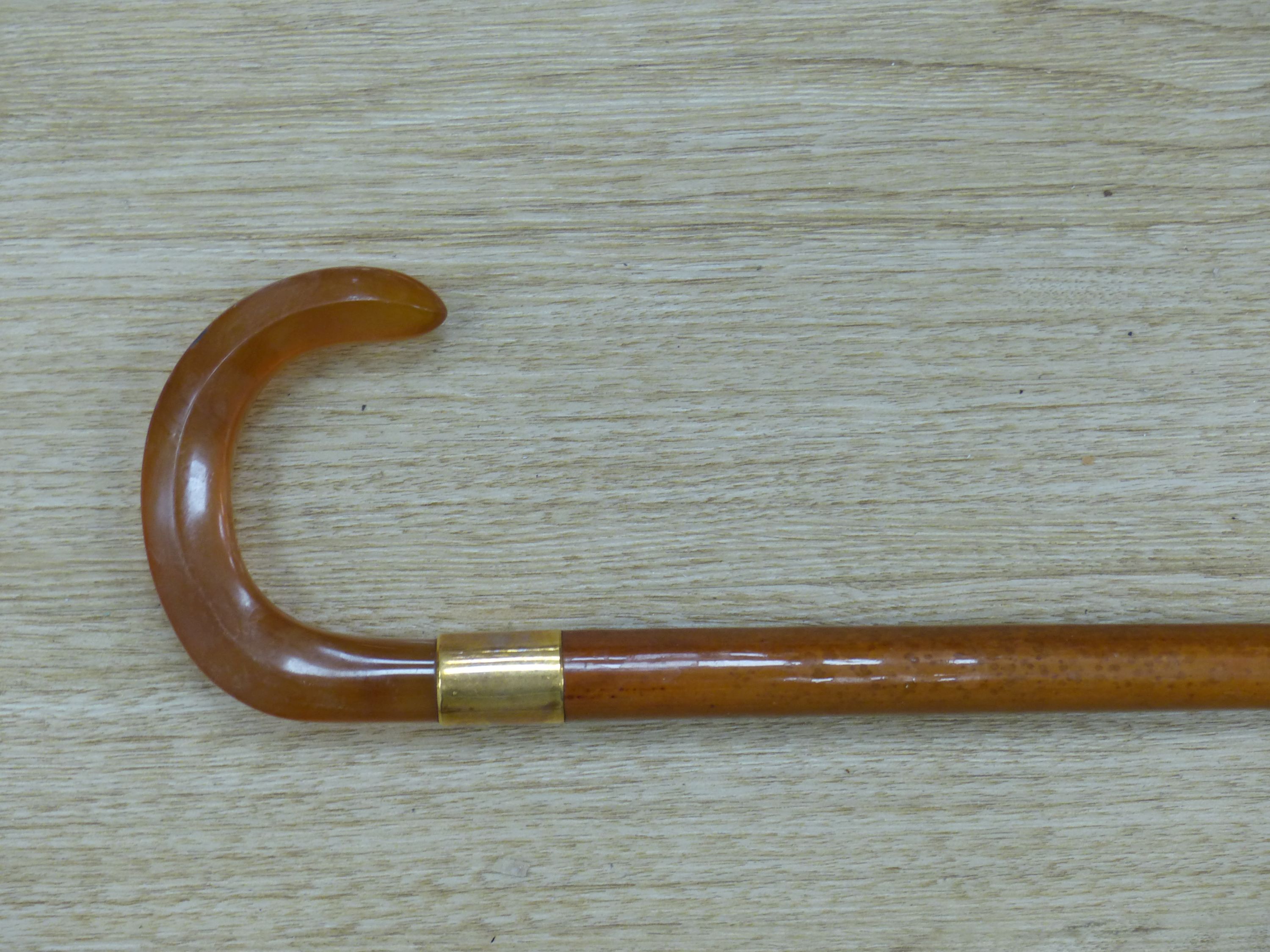 Art Art Deco walking stick with amber-coloured Bakelite handle and 18ct gold band, length 81cm